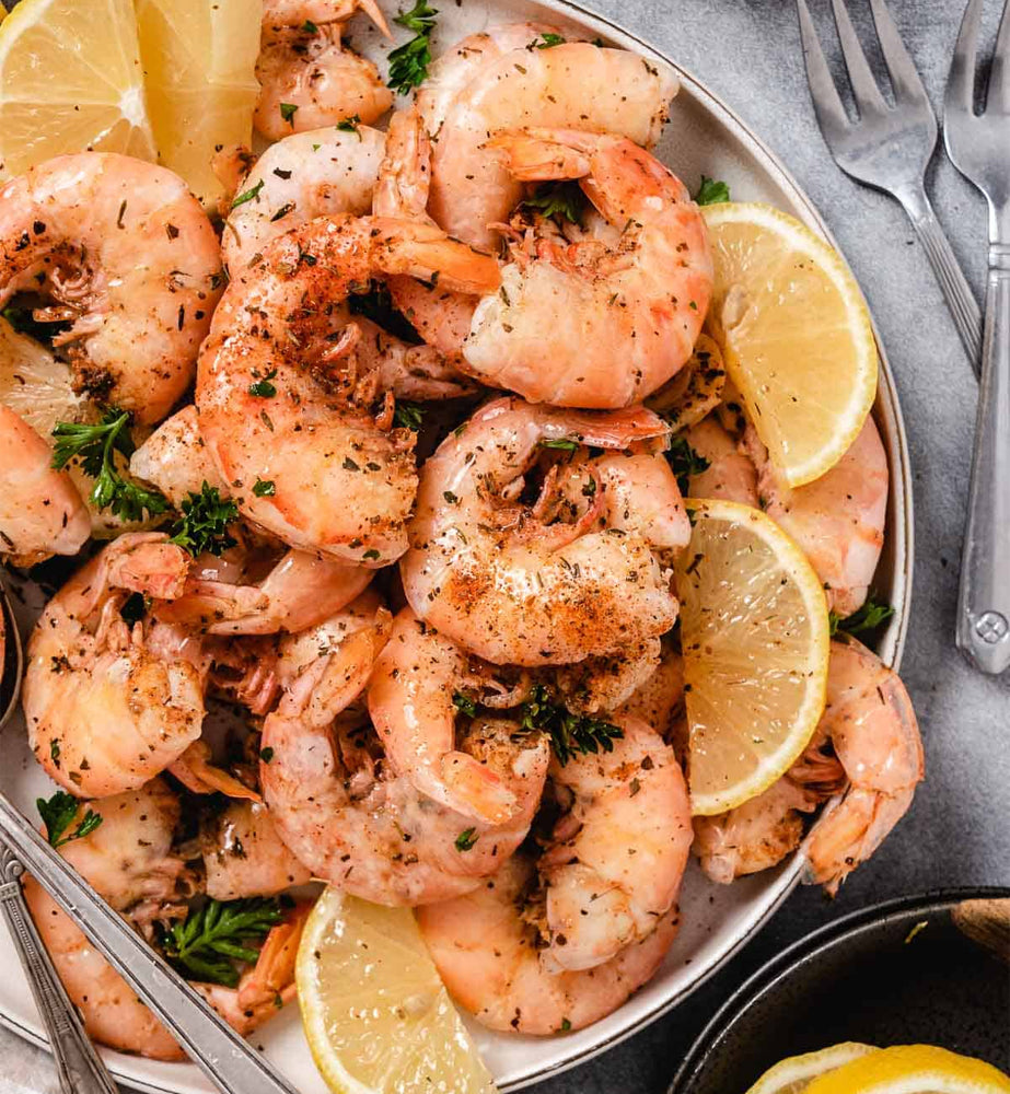 Seasoned shrimp with lemon slices and herbs, fresh seafood meal ready to serve