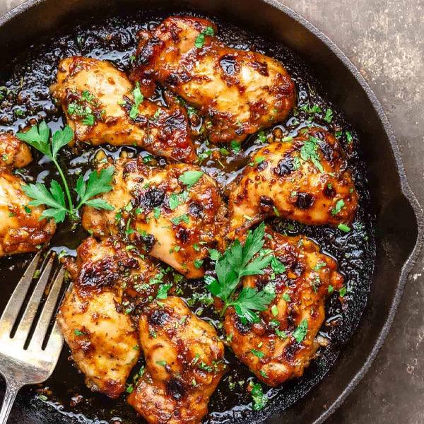Juicy garlic butter chicken thighs in cast iron skillet, garnished with fresh parsley