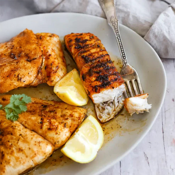 Picture of a cajun red snapper dish with lemon.