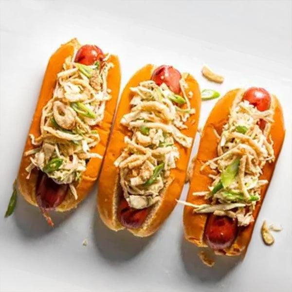 Three gourmet hot dogs topped with crispy onions and green onions, fresh seafood-inspired meal