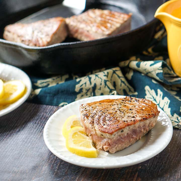 Picture of delcious tuna steak with a slice of lemon and a lemon Dijon cream sauce.