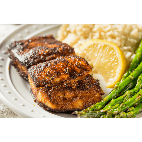 Grilled salmon with asparagus and rice, garnished with lemon slice for fresh seafood meal