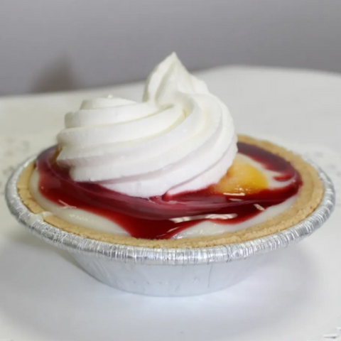Small pie with whipped cream on a gray background